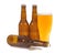Glass of cold beer with several brown lager pils bottles isolated on white background