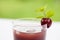 Glass of Cold cherries juice in garden