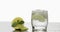 Glass with a cold drink with leaves of mint, lime, lemon and ice cubes