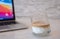 A glass of cold milk coffee or dirty coffee and blur photo of laptop on The table