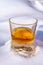 Glass of cold scotch single malt whisky on white snow