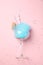 Glass with cotton candy and macaroon on pink background