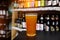 Glass of craft beer at the bar. Assortment of bottles on a blurred background