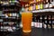 Glass of craft beer at the bar. Assortment of bottles on a blurred background.