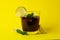 Glass of Cuba Libre on yellow background
