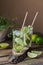 Glass of cucumber cocktail or mocktail, refreshing summer drink with crushed ice and sparkling water on a wooden background