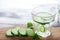 Glass of cucumber infused water on wooden board