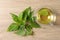 Glass cup of aromatic nettle tea and green leaves on wooden table, flat lay