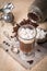 Glass Cup of coffee with marshmallow, milk jug and coffee beans