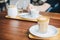 A glass cup of Piccolo latte on wooden table in the coffee shop.