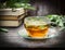 Glass cup with sage tea on rustic table with books, close up