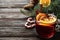 Glass cup of tasty mulled wine on black wooden table