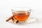 Glass cup of tea with cinnamon sticks. White background. Isolated. Hot spiced cinnamon tea