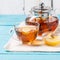 Glass cup of tea with lemon, glass teapot and honey.