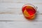 Glass cup with tea and lemon standing on a white painted wooden surface. Background for hot drinks. Soft and tonic drinks