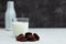 A glass cup of yogurt, yogurt or ayran on a white table, next to it lies a handful of dried fruits, dried dried apricots. In the