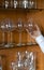 Glass cups on a glass shelving with an appearing hand