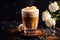 Glass of Dalgona Coffee with cinnamon on dark background with white roses, homemade coffee drink. Coffee latte made of instant