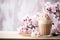 Glass of Dalgona Coffee with whipped cream on a light wooden table with a lilac sprig against light background, copy space. Creamy