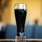 Glass of dark beer in bar or in pub close up. Real scene. Concept of beer culture, Craft brewery, festivals and meetings