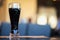 Glass of dark beer in bar or in pub close up. Real scene. Concept of beer culture, Craft brewery, uniqueness of beer