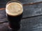 A glass of dark craft beer porter on a wooden table