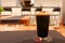 Glass of dark juicy craft beer with beatiful foam in a craft bar