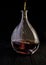 Glass decanter with brandy on black background