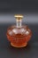 The glass decanter filled with brandy and covered with a golden stopper.