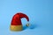 Glass decorations. Glitter Santa Hat with Bell on light blue background