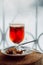 Glass of delicious cherry glintwein or mulled hot wine thread on vintage wooden background