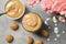 Glass of delicious dalgona coffee, ingredients and walnut shaped cookies on light grey table, flat lay