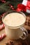 Glass of delicious eggnog on wooden table, closeup