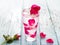 Glass delicious refreshing drink of rose petal flower on blue wooden background