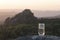 a glass of drinking pure mineral water in a transparent glass, against the background of a sunset in the mountains