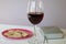 A glass of dry red wine and broken unleavened bread lie on a plate. To celebrate the Lord`s Supper. Nearby lies the Bible