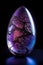 a glass egg with a tree inside of it on a black background with a blue light underneath it and a purple light underneath it and a