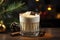 Glass of eggnog covered with layer of whipped cream. Traditional Christmas drink is decorated with cinnamon sticks