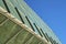 Glass exterior of greenhouse or biodome with metal and clear pannels in industrial area with clear blue sky