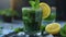 A glass filled with green tea, garnished with slices of lemon and sprigs of fresh mint
