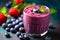 A glass filled with a luscious blueberry smoothie, garnished with a few whole blueberries on top, conveying the idea of a