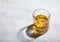 Glass of finest whiskey with ice cubes on light background