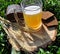 A glass of foamy bright clear beer with spikelets and bread