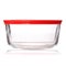 Glass food container with red plastic lid on white