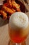 Glass of fresh beer and fried chicken wings