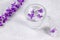 Glass with fresh clear water and ice cubes with purple flowers