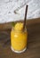 Glass of fresh mango smoothie on a wooden table