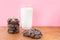 Glass of fresh milk with crunchy baked chocolate sugar cookies on wooden table with pink background