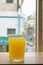 A glass of fresh orange juice drink with downtown window view background.