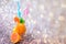 A glass of fresh orange nectar with ice and a grapefruit next to it on a gray abstract background